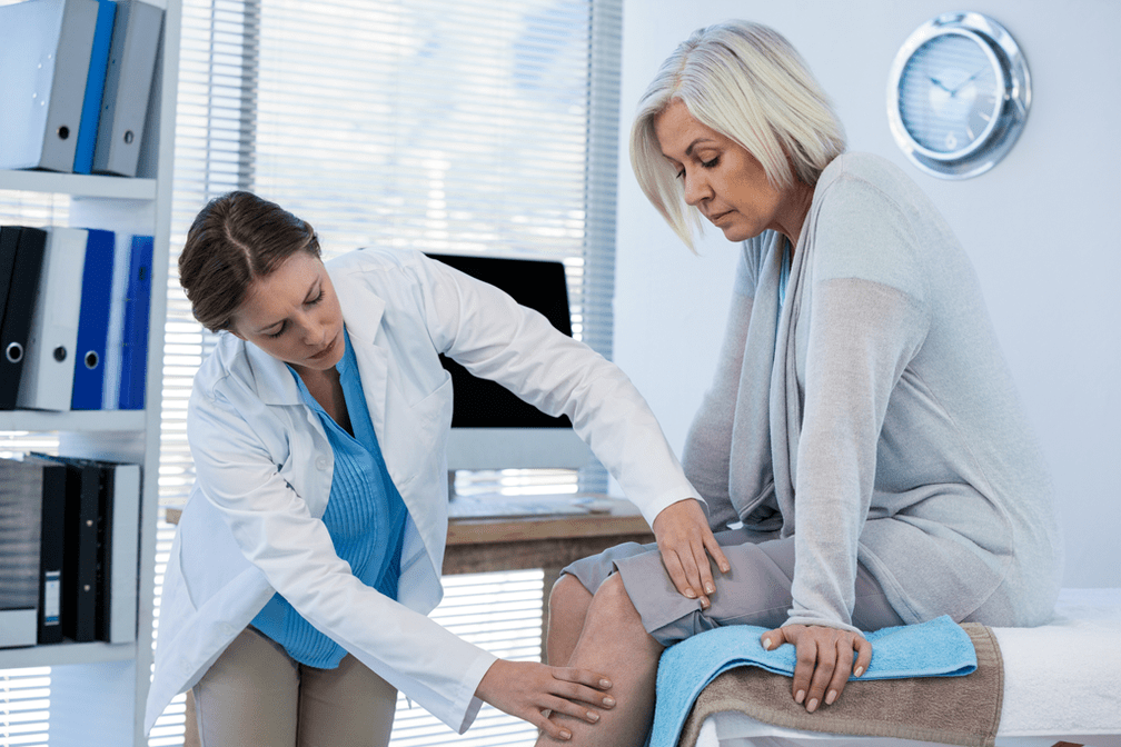 Pesakit arthrosis yang memerlukan terapi diperiksa oleh doktor