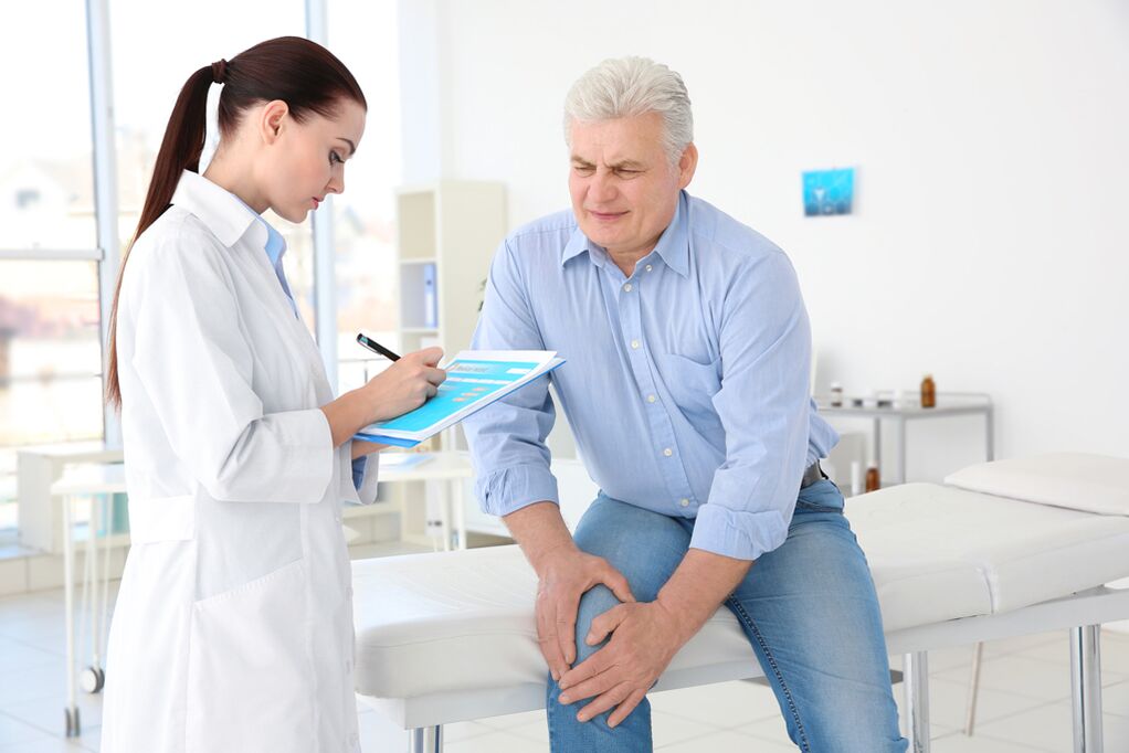 Seorang doktor menetapkan rawatan untuk arthrosis sendi lutut kepada pesakit